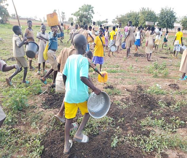Élèves arrosant le jardin de leur école