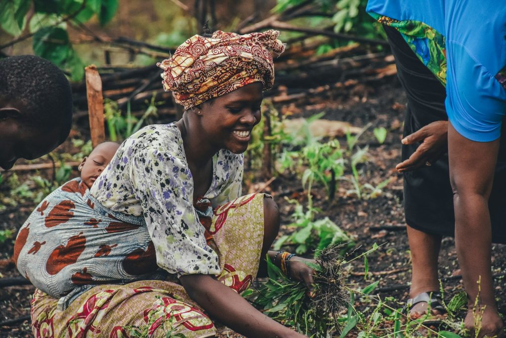Une agricultrice sourit en repiquant des plants